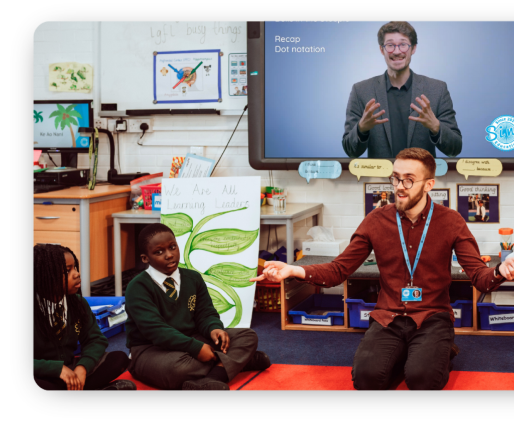 Teacher is leading a joyful class music lesson with on-screen specialist modelling from Sing Education Classroom.