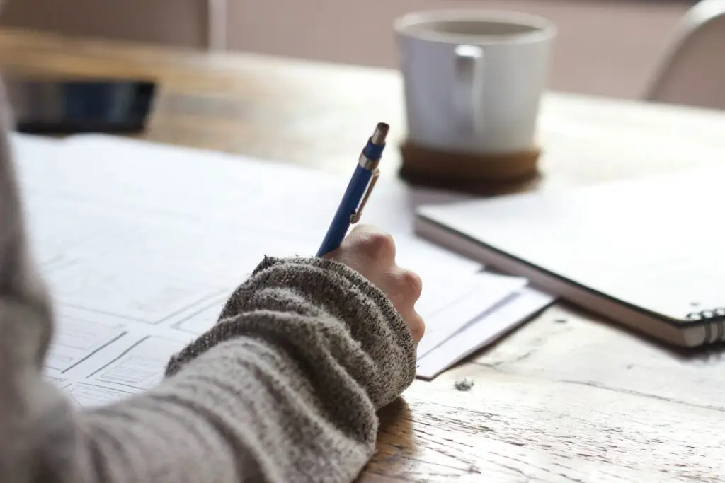 A student is taking an exam. The photo is a close up of their pen writing on the page